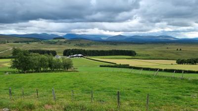 Mixed farmland and moorland with mountains in the background.