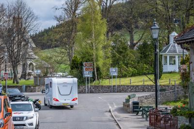 Parked cars, a motorbike, and a campervan in Braemar.