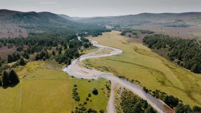 Aerial view, taken from a drone, of the Slugain Burn and the surrounding landscape, including greenspace and woodland.