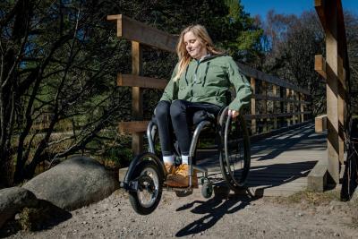 Person crossing a bridge using an off road wheelchairs.